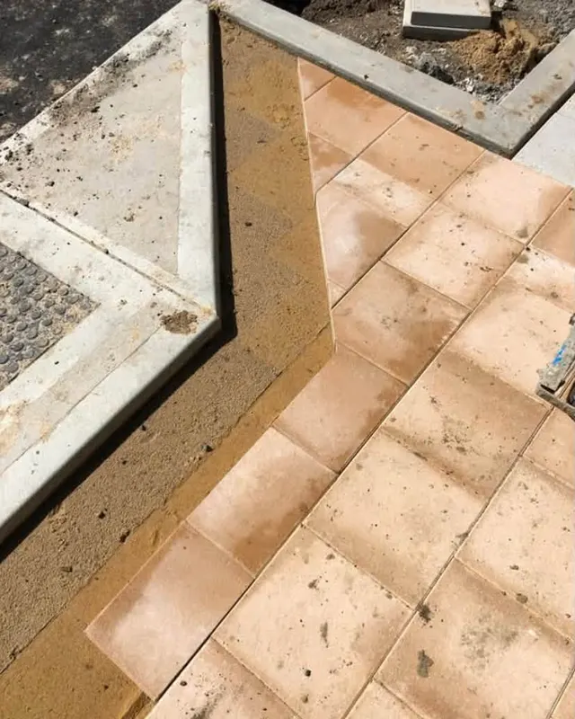 Terracotta coloured pavers meeting a concrete edge