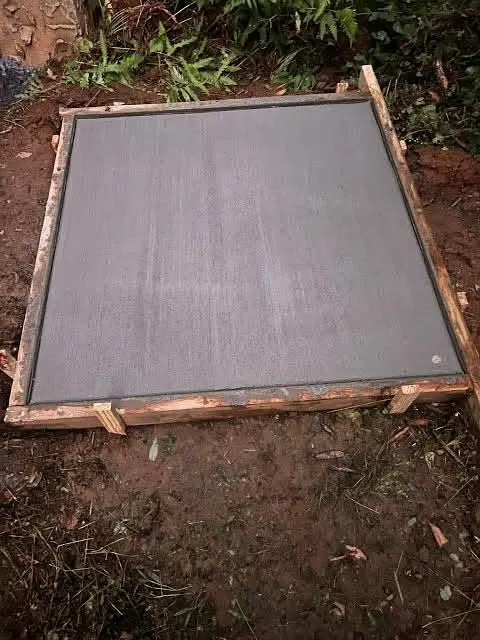 A concrete slab inside timber formwork on red dirt